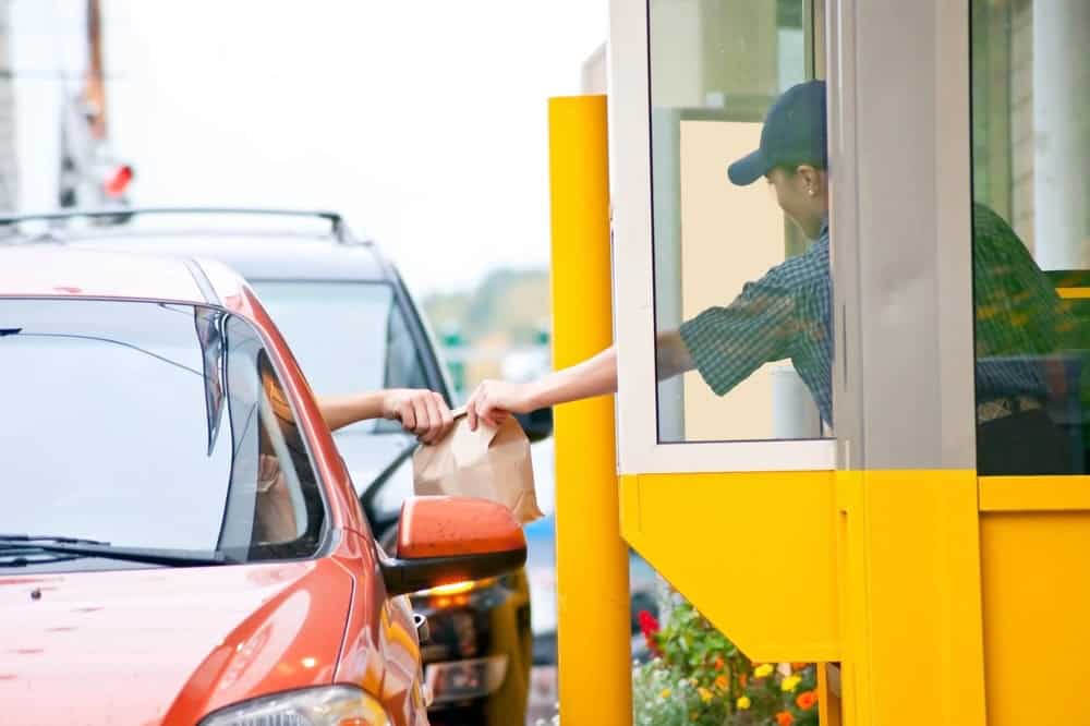 driver receiving bag of food at drive-thru