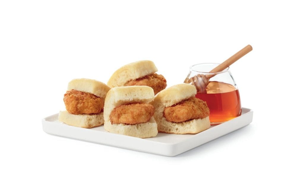 little chicken pieces on little rolls and some honey