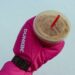 Hand with red Dunkin' glove holding a coffee