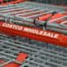 Close-up picture of shopping cart with red handle that says "Costco"