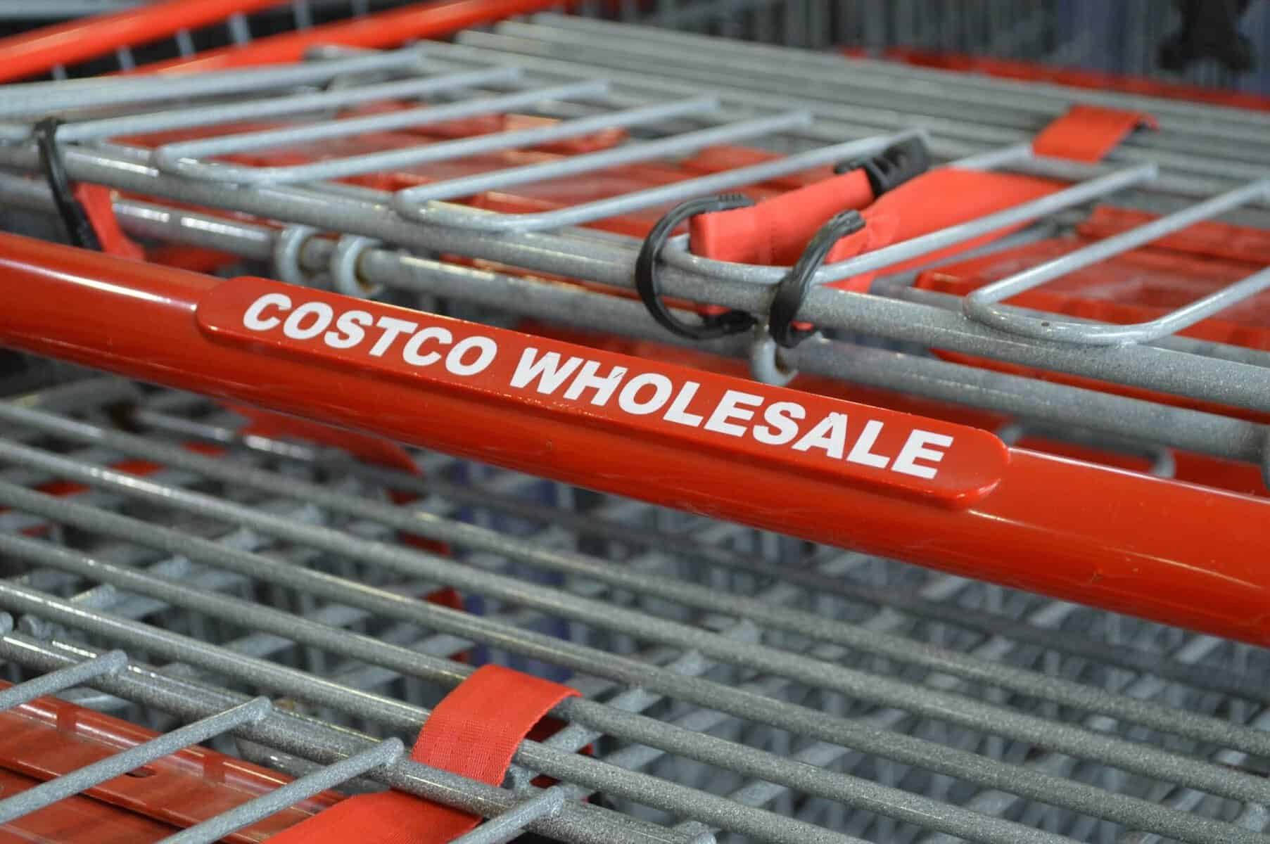 Close-up picture of shopping cart with red handle that says "Costco"