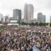 crowd in First Ward Park for music. Charlotte skyline in the background