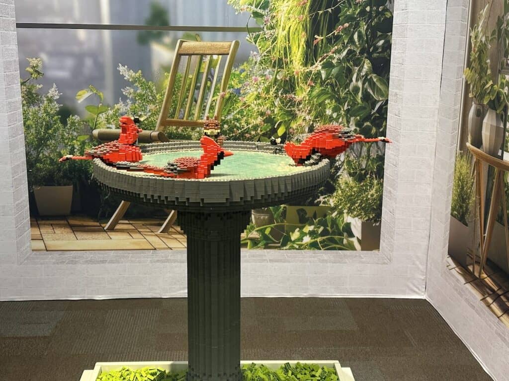 Sculpture of red birds at bird feeder, made from LEGOs