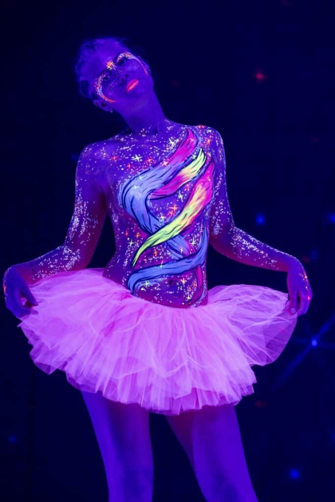 person painted with body paint under black light