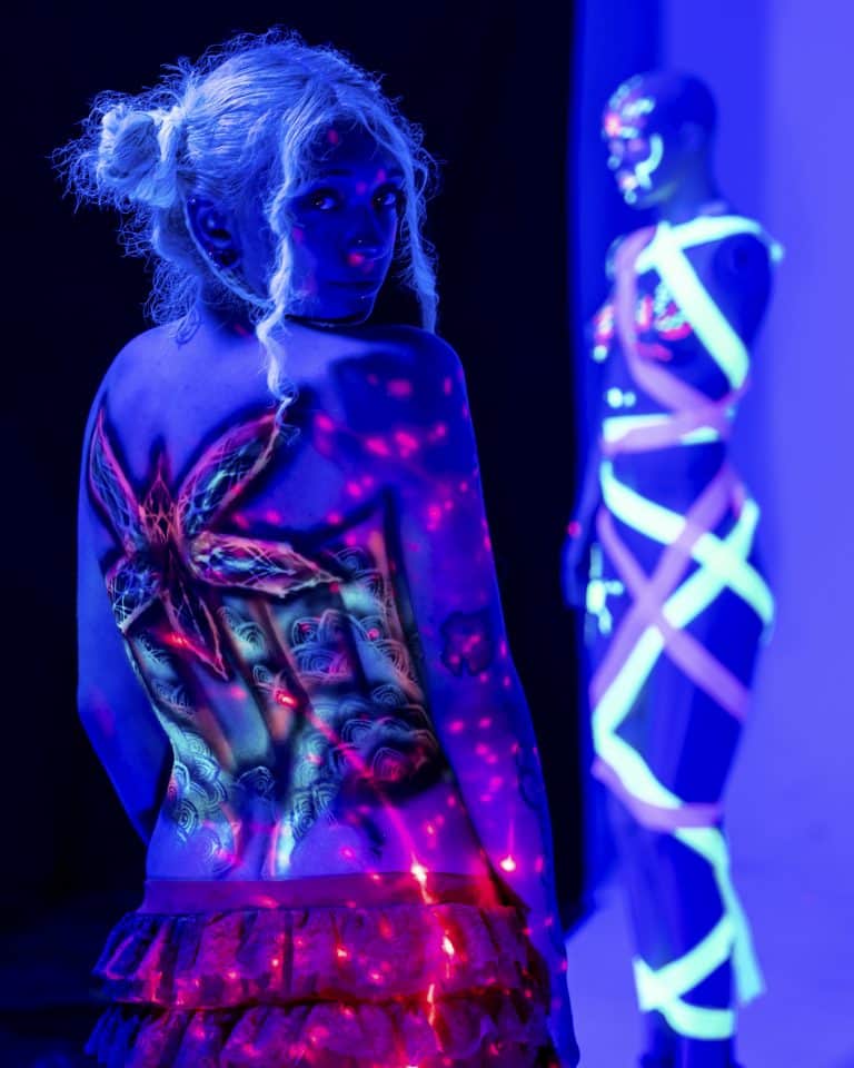 People with body paint under black light