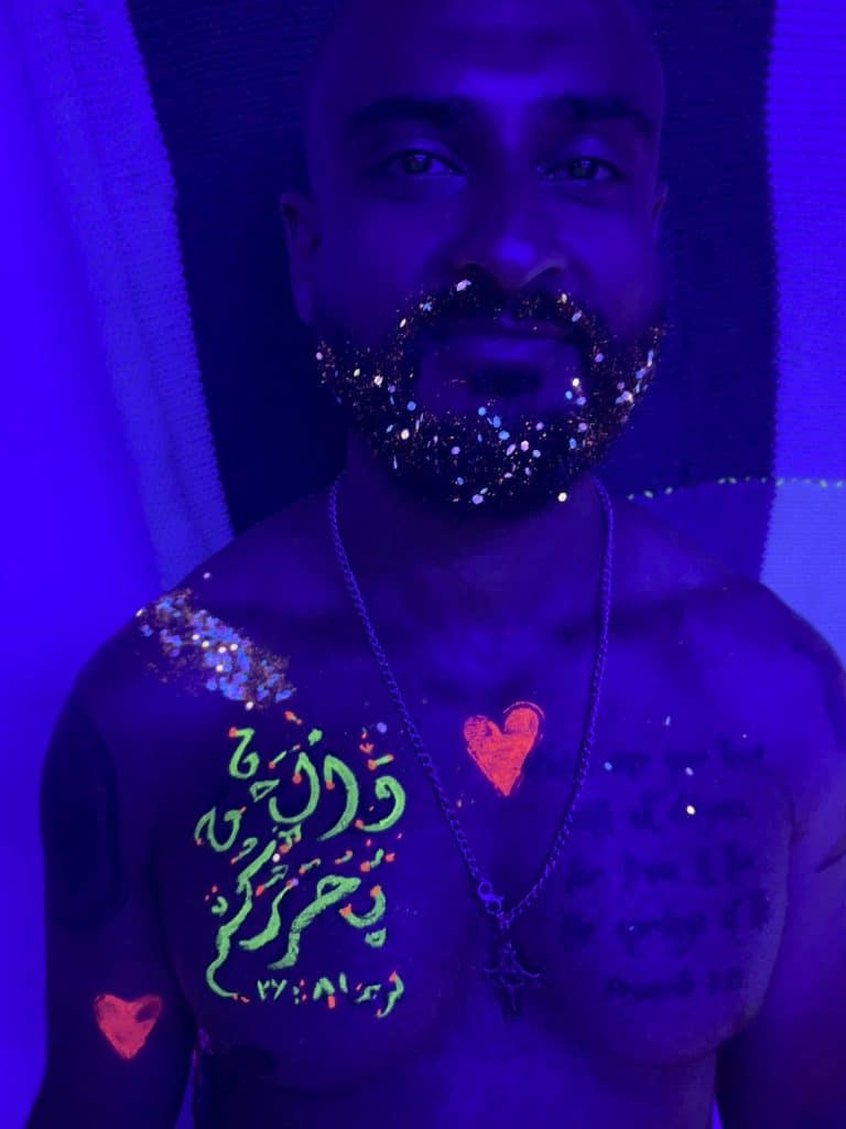 Person painted with body paint under black light