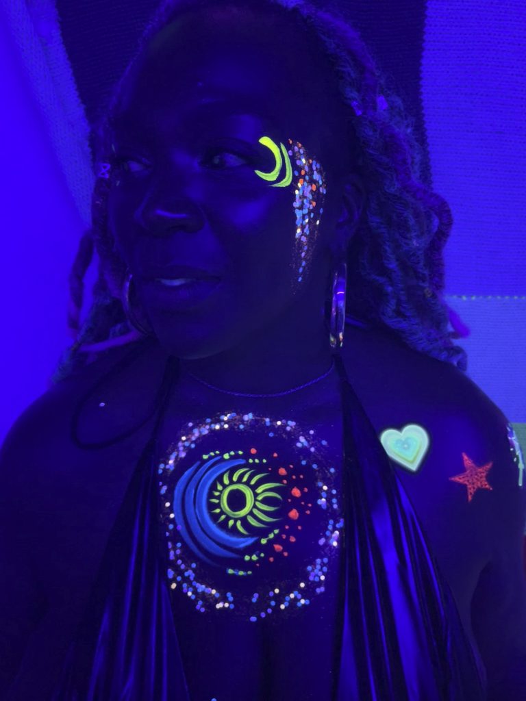 woman painted with body paint under balck light