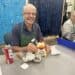 Man fixing duck or chicken alarm clock at Repair Cafe Charlotte