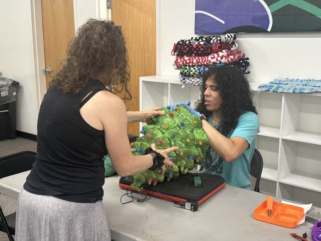 Person fixing Christmas tree decoration at Repair Cafe Charlotte